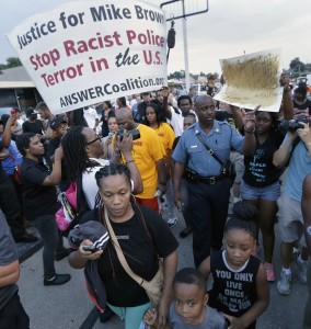 In this Aug, 16, 2014 file photo, Missouri Highway Patrol Capt. Ron Johnson walks among people protesting the police shooting death of Michael Brown in Ferguson, Mo. (AP Photo/Charlie Riedel, File)
